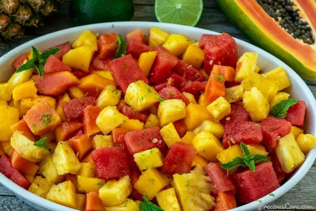 Ghana Food - Fruit Salad Made with Mangoes, Pineapples, Bananas, And Papaya, All Seasoned with Lime and Ginger, and Garnished with Toasted Coconut Flakes